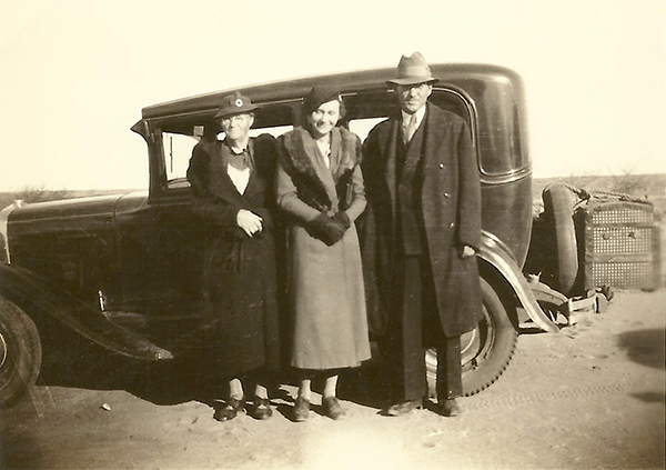 Johanna, Mary, and Fred Gifford in front of a car.